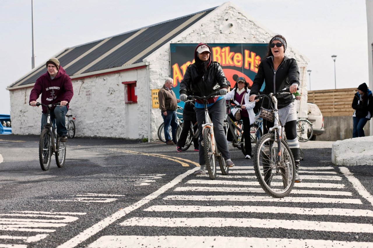 Aran Bike Hire on Inis Mór - Group of people cycling across zebra crossing 