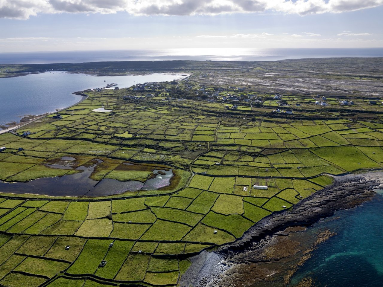 The island of Inis Mór is made of green patchword fields which are separated by grey drystone walls.